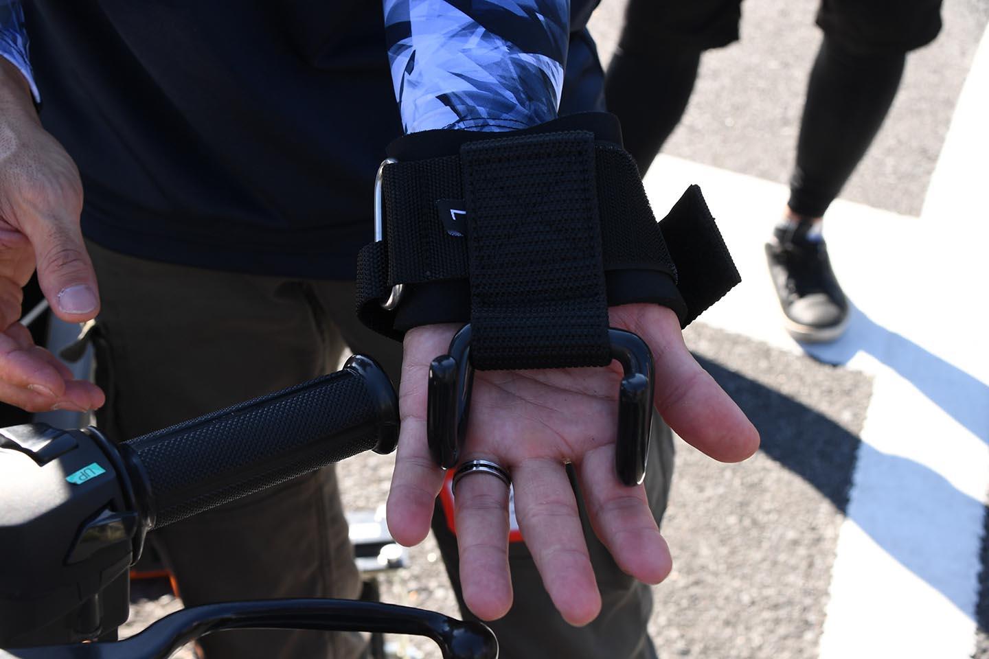 握力が無くてもハンドル操作ができるように手首にバンドを装着してフックをハンドルに掛けるサポーターを導入。